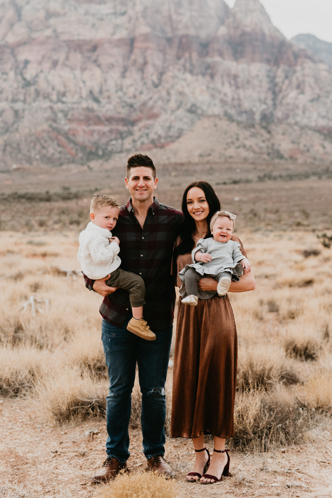 Our Holiday Family Pictures featured by top Las Vegas lifestyle blog, Outfits & Outings: image of a cute family posing in the Nevada desert