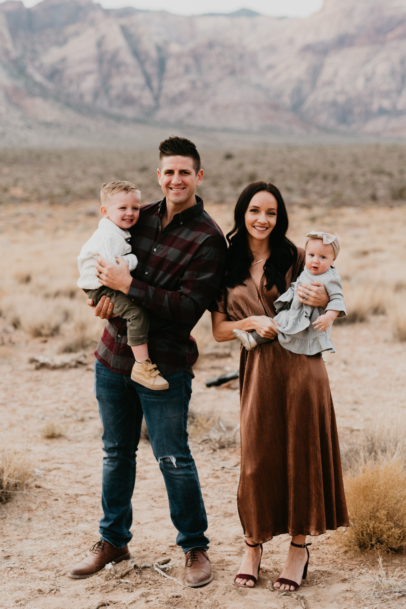 Our Holiday Family Pictures featured by top Las Vegas lifestyle blog, Outfits & Outings: image of a cute family posing in the Nevada desert
