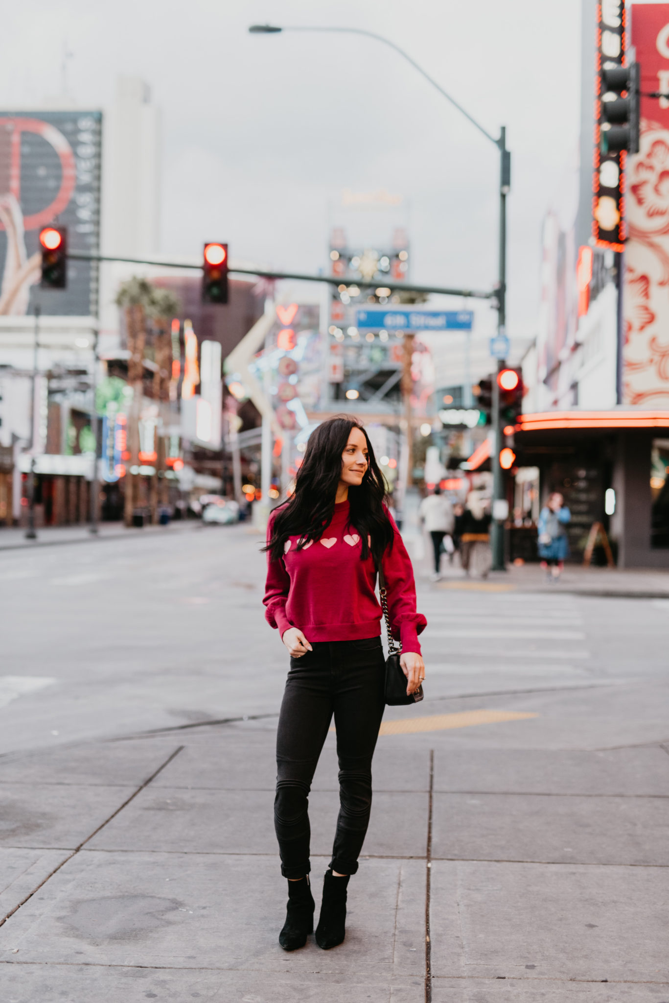The Fifth Label Valentines day sweater styled by top US fashion blog, Outfits & Outings: image of a woman wearing a heart knit sweater, Good American skinny jeans, and Marc Fisher booties