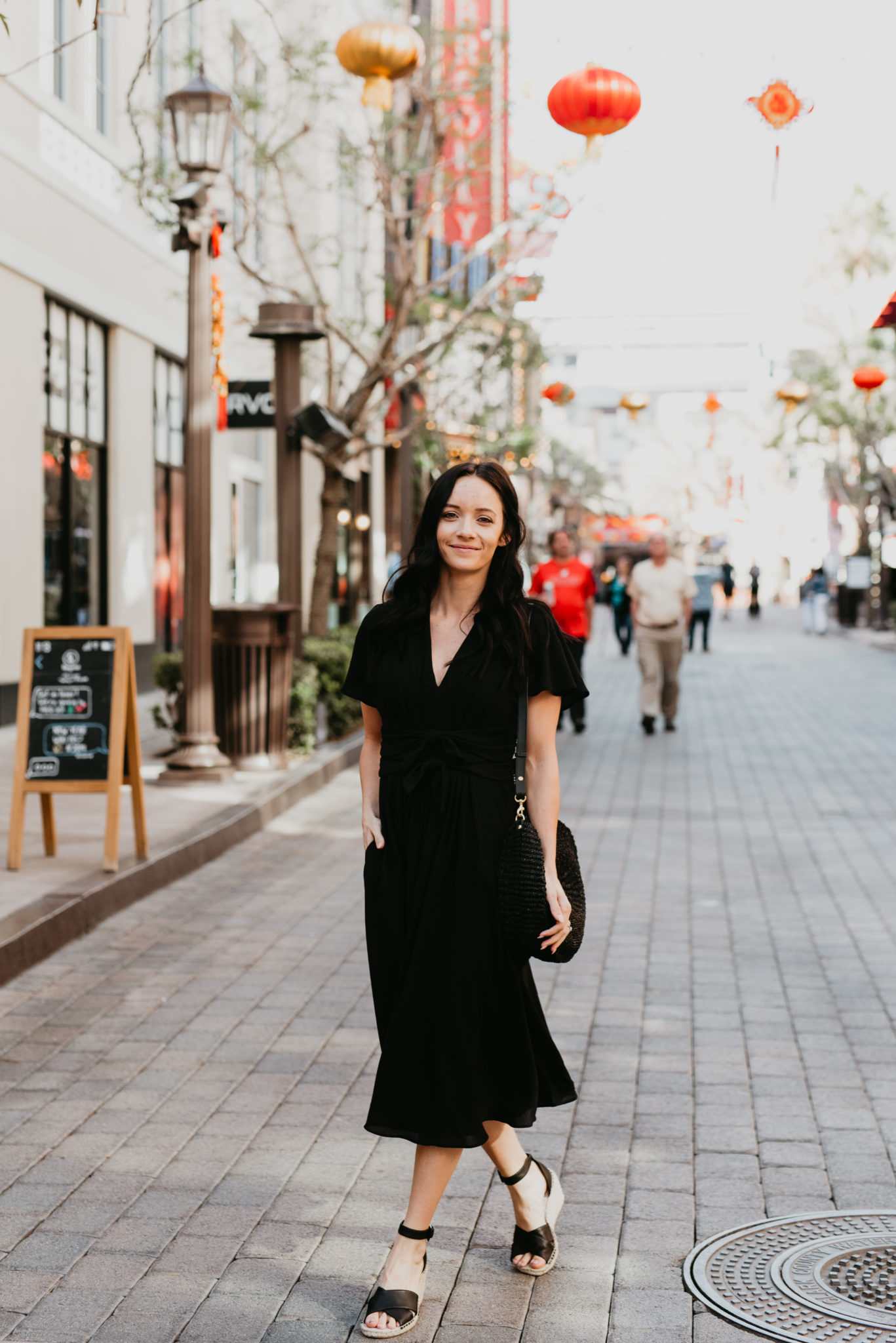 Cute Spring dress look styled by top US fashion blog, Outfits & Outings: image of a woman wearing a black Gal Meets Glam midi dress, Caslon espadrille sandals, and a Clare V straw bag
