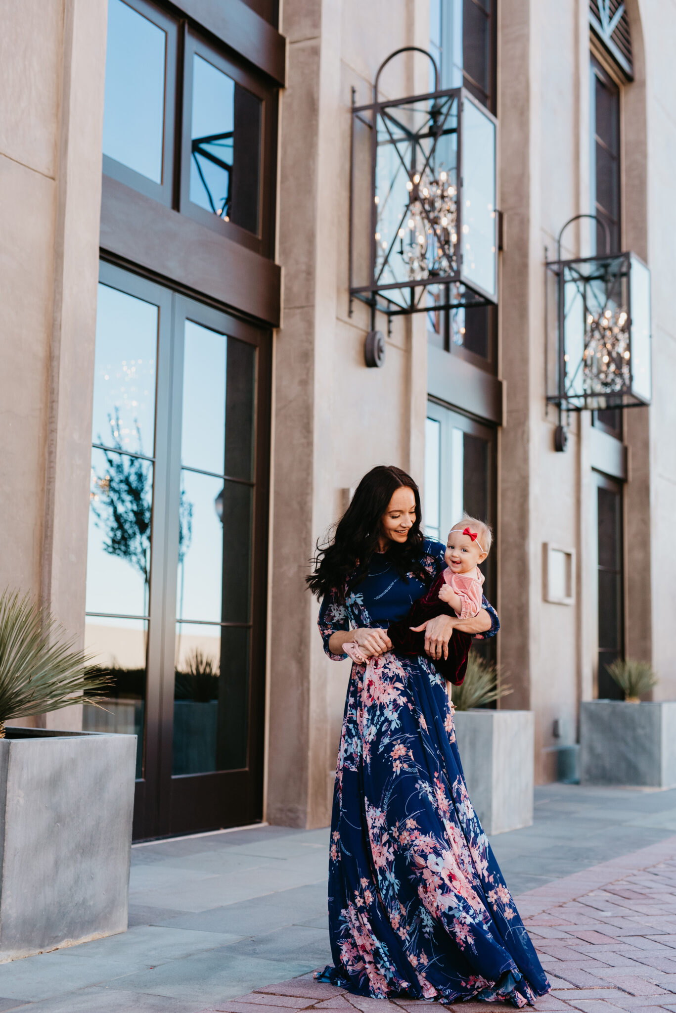 Cute Easter Dresses for Spring featured by top US fashion blog, Outfits & Outings: image of a woman wearing a maxi floral dress with her baby wearing a pink color block dress
