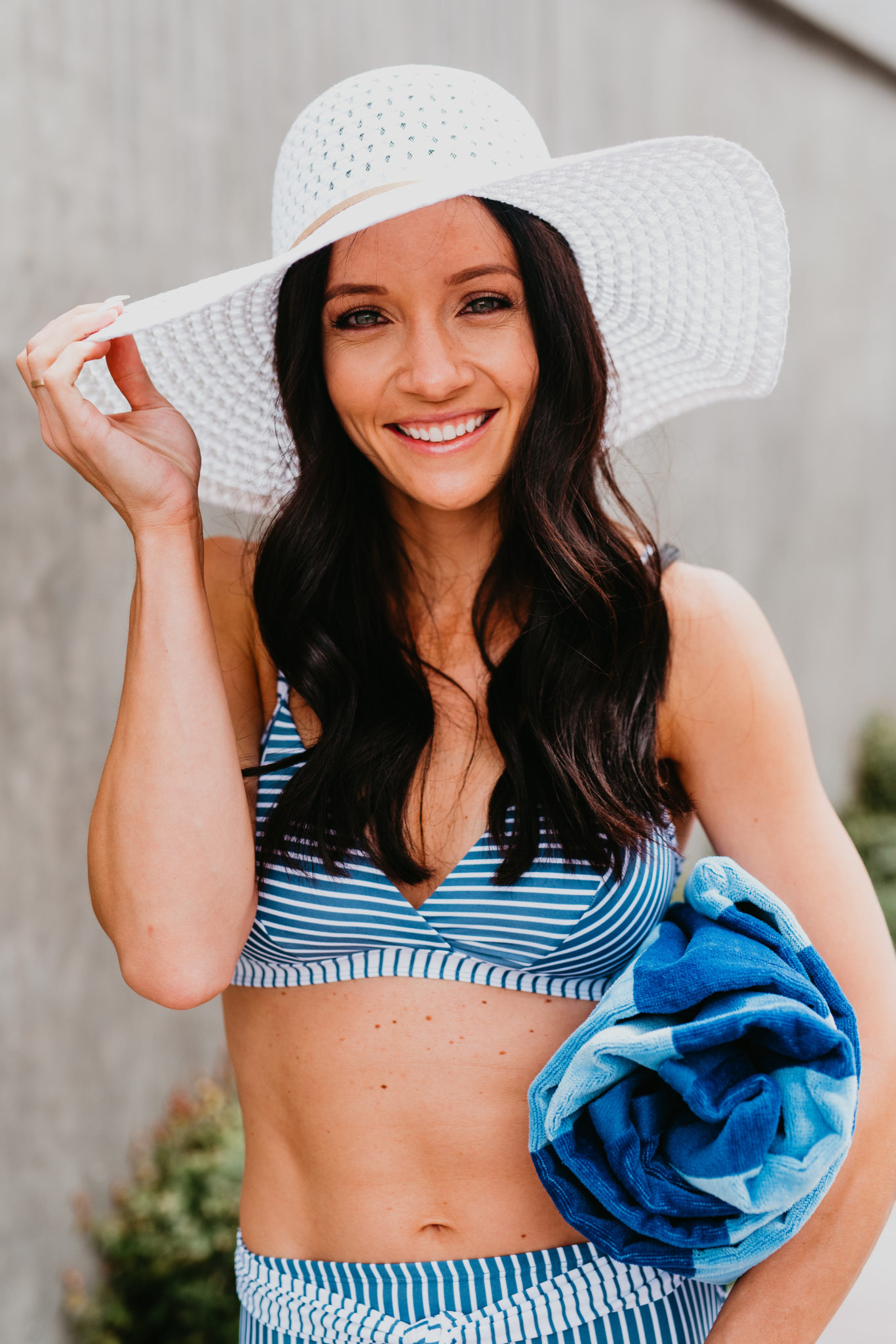 Best Brands at Walmart featured by top US fashion blog, Outfits & Outings: image of a woman wearing a Time and Tru striped bikini, Time and Tru straw circle tote, Time and Tru sandals, Time and Tru straw floppy hat, and Mainstay striped beach towel
