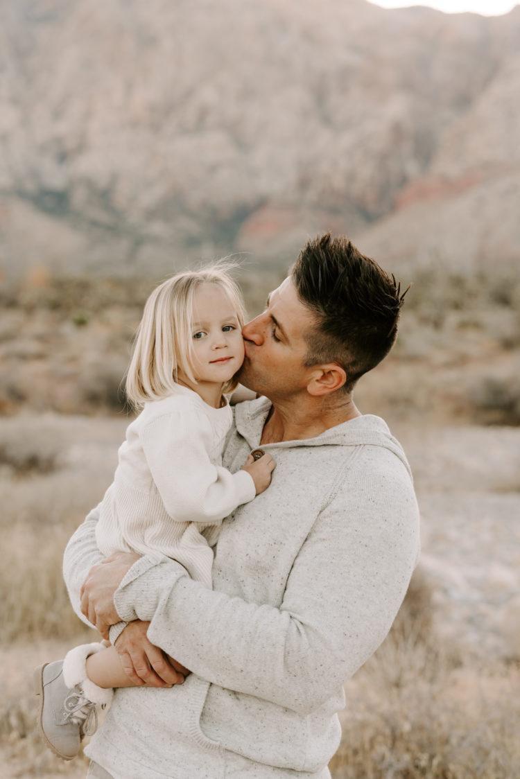 Family Picture Ideas by popular Las Vegas fashion blog, Outfits and Outings: image of a dad holding his young daughter in the desert. 
