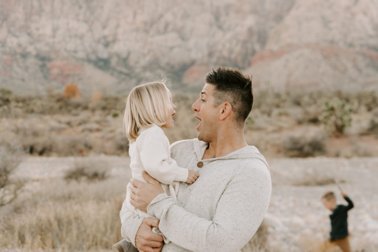 Family Picture Ideas by popular Las Vegas fashion blog, Outfits and Outings: image of a dad holding his young daughter in the desert. 
