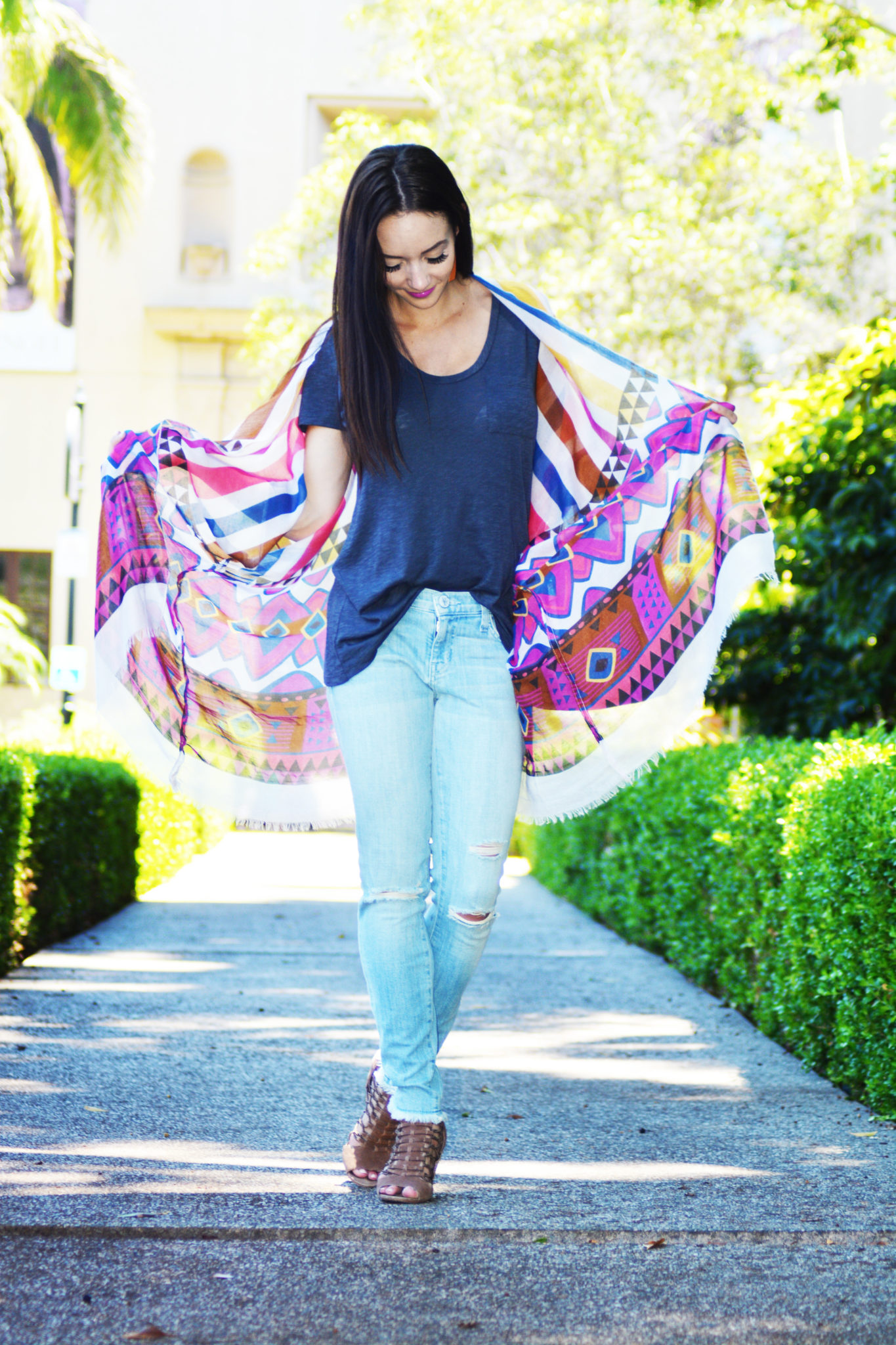 Cute Spring Outfits featured by top US fashion blog Outfits & Outings; Image of a woman wearing blue tee and jeans.