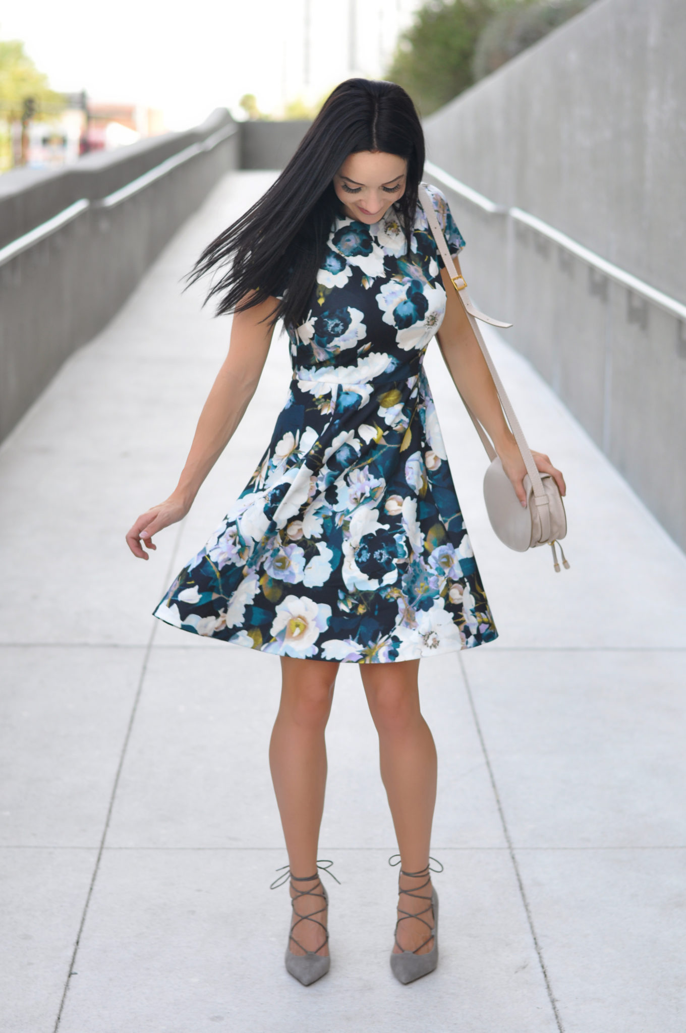 Cute Spring Outfits featured by top US fashion blog Outfits & Outings; Image of a woman wearing floral dress.