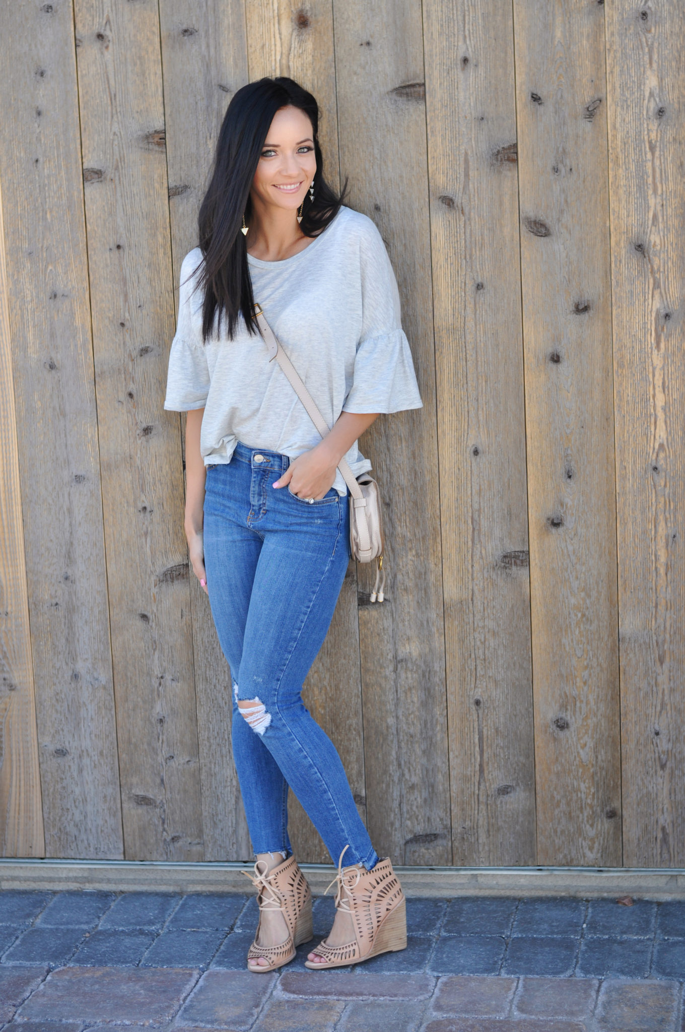 Cute Spring Outfits featured by top US fashion blog Outfits & Outings; Image of a woman wearing grey top, jeans and nude wedges.