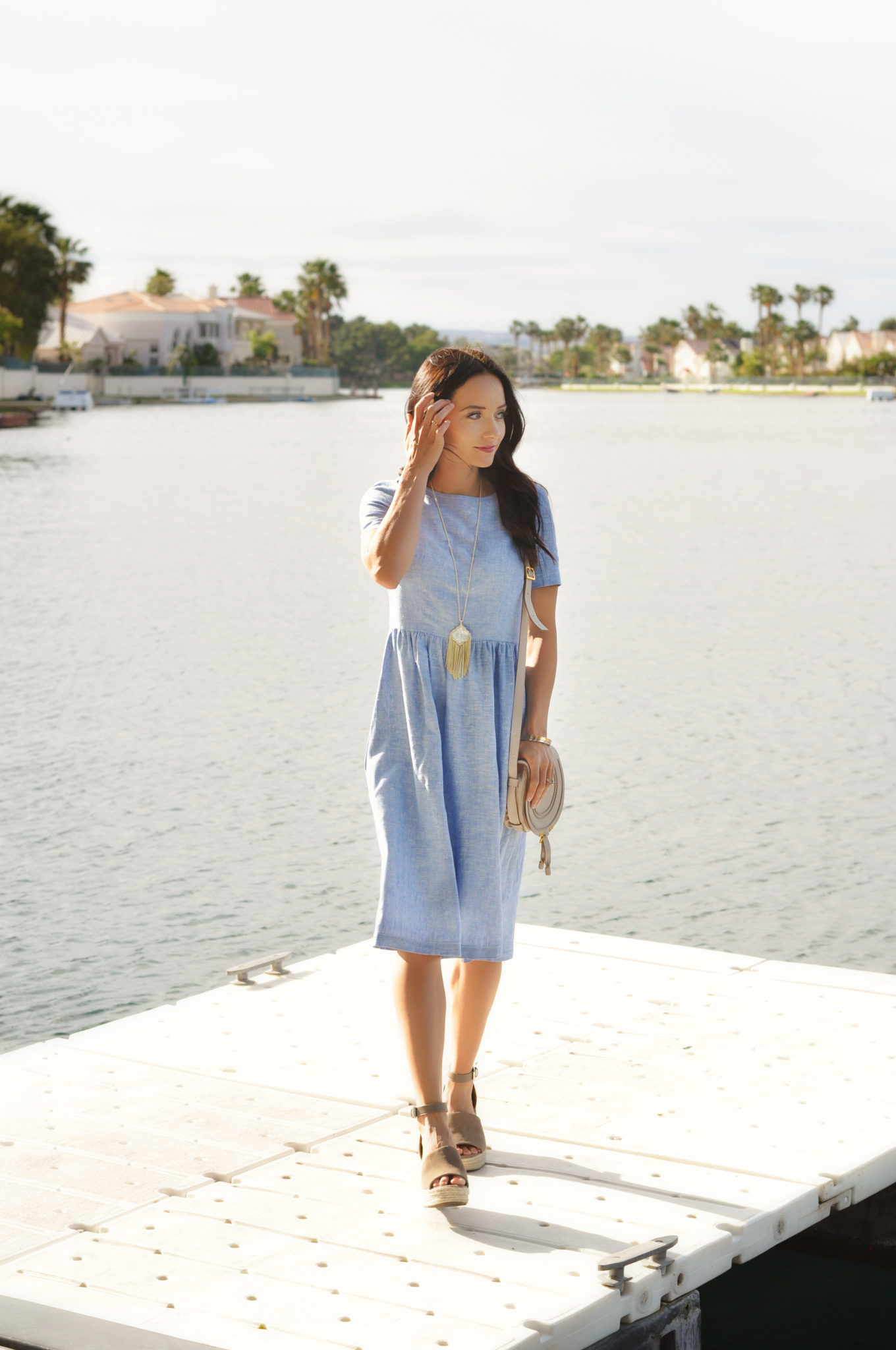 Cute Spring Outfits featured by top US fashion blog Outfits & Outings; Image of a woman wearing blue dress and sandals.