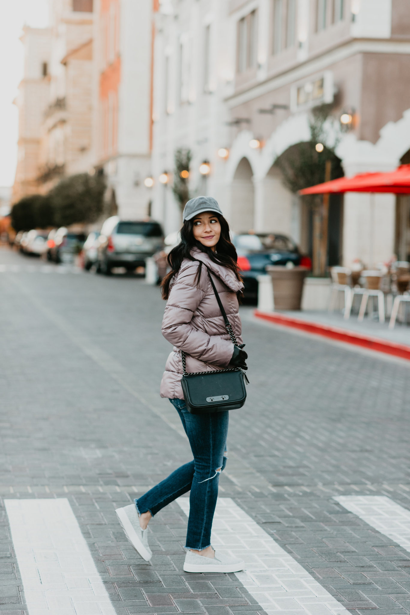 casual winter outfit puffy jacket sneakers baseball cap and ripped jeans - Puffer Jacket Outfit styled by popular Las Vegas fashion blogger, Outfits & Outings