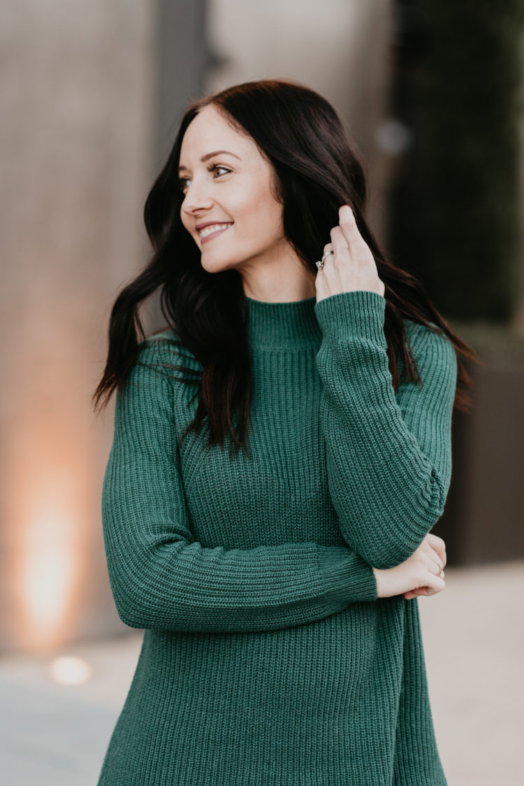 green tunic sweater and blunt brunette haircut