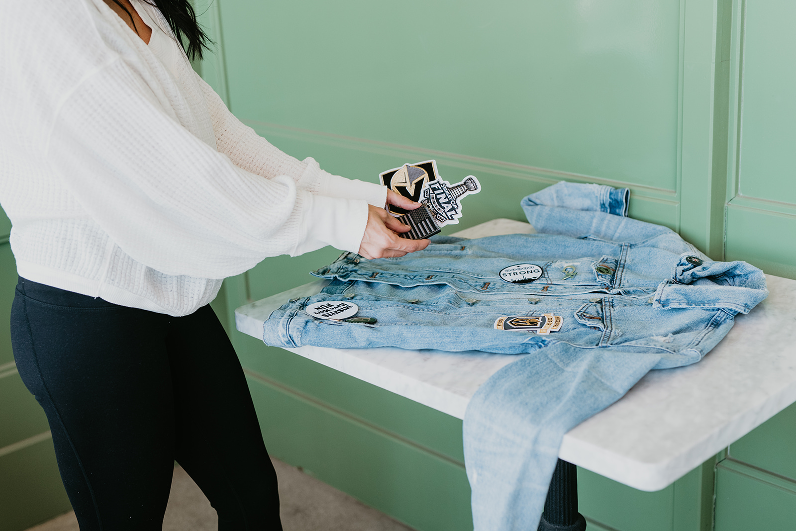 Custom Denim Jacket with Patches featured by top US fashion blog, Outfits and Outings: image of a woman wearing a custom Madewell denim jacket adorned with vinyl VGK letters.