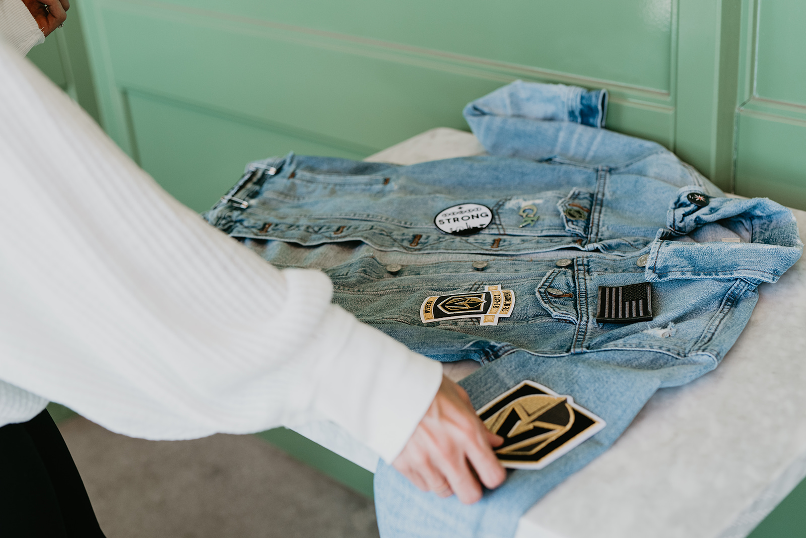 Custom Denim Jacket with Patches featured by top US fashion blog, Outfits and Outings: image of a woman wearing a custom Madewell denim jacket adorned with vinyl VGK letters.