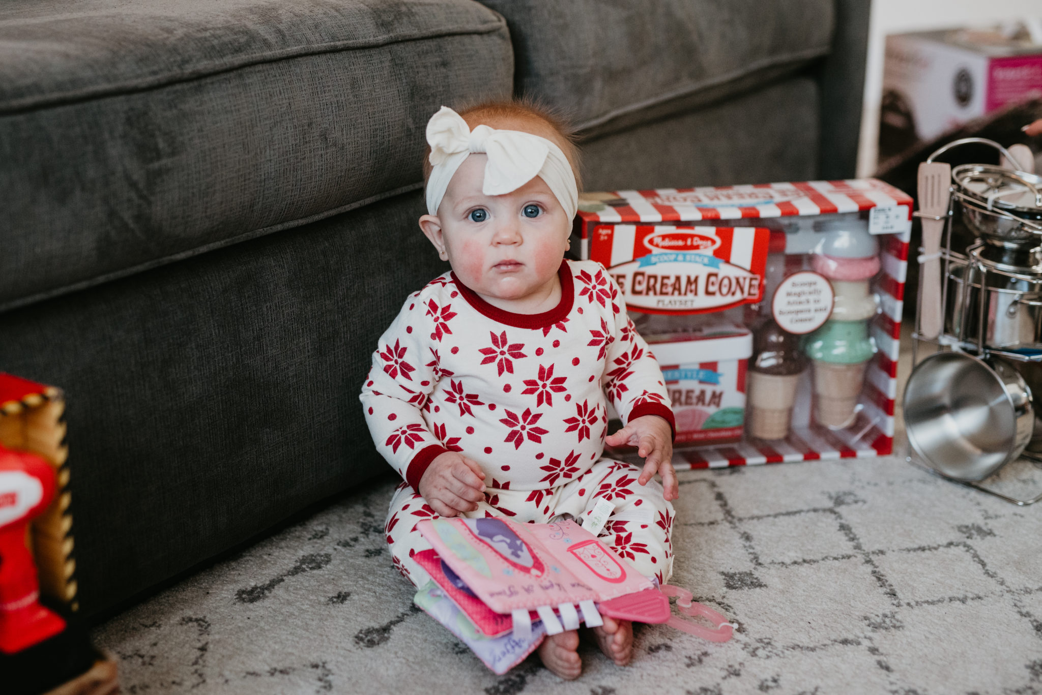 Top Kohl's Gifts for Kids featured by top Las Vegas life and style blog, Outfits & Outings: picture of a baby girl sat next to a couple of Kohls gifts