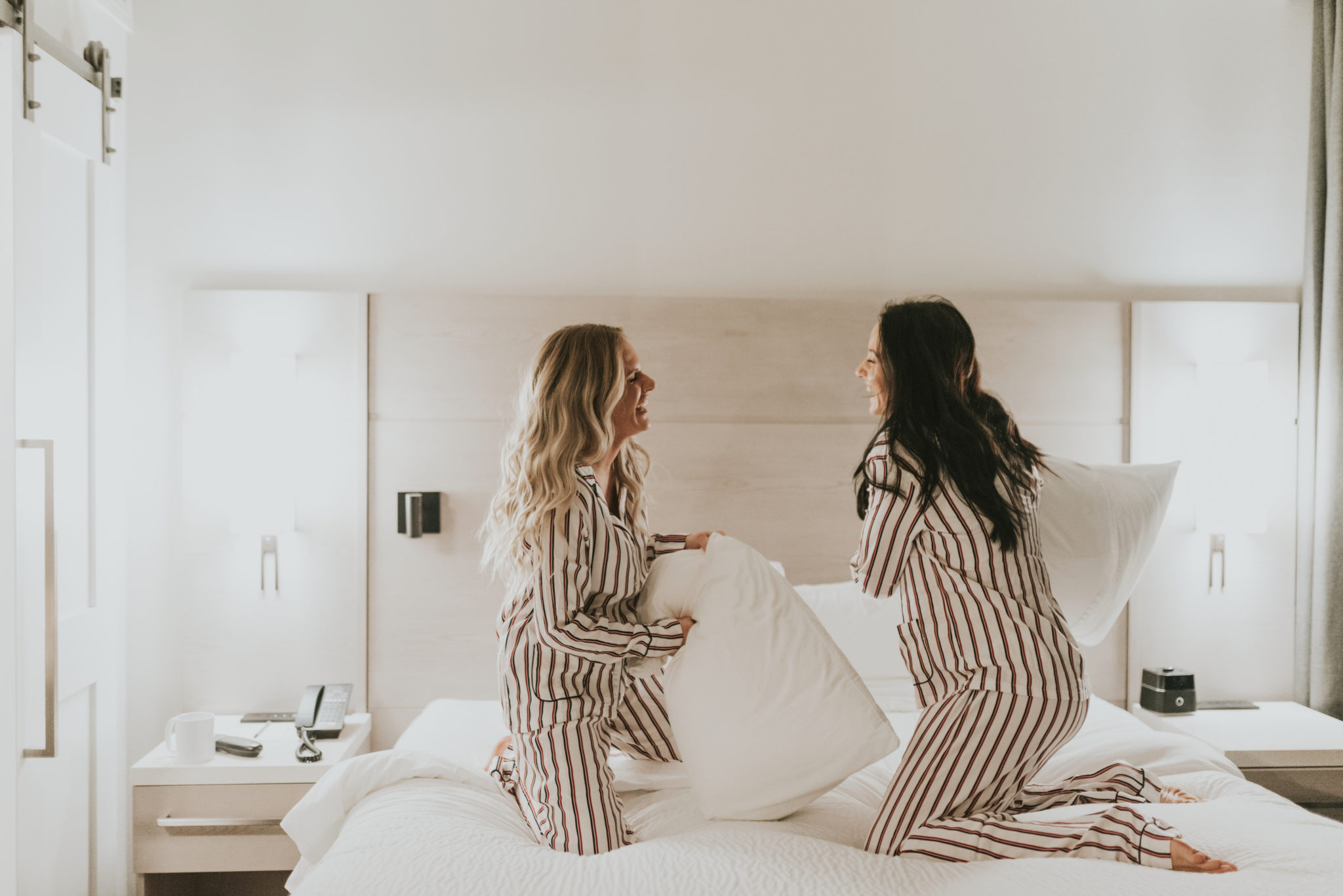 Things to do in Healdsburg featured by top US travel blog, Outfits & Outings: image of women having a pillow fight at Hotel Trio in Healdsburg