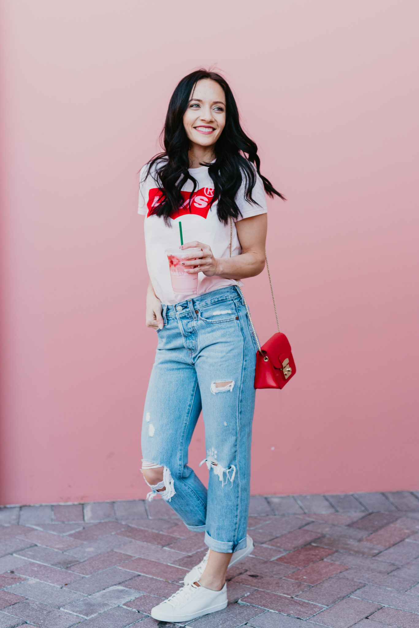Cute Spring Tees Roundup featured by top US fashion blog, Outfits & Outings: image of a woman wearing a Levi’s graphic tee.