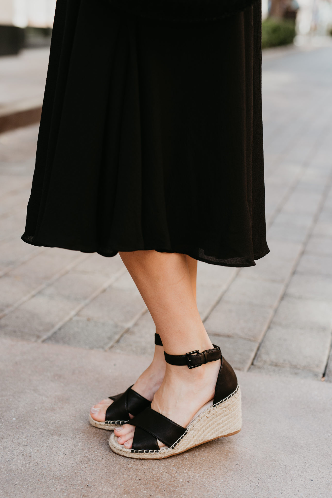 Cute Spring dress look styled by top US fashion blog, Outfits & Outings: image of a woman wearing a black Gal Meets Glam midi dress, Caslon espadrille sandals, and a Clare V straw bag