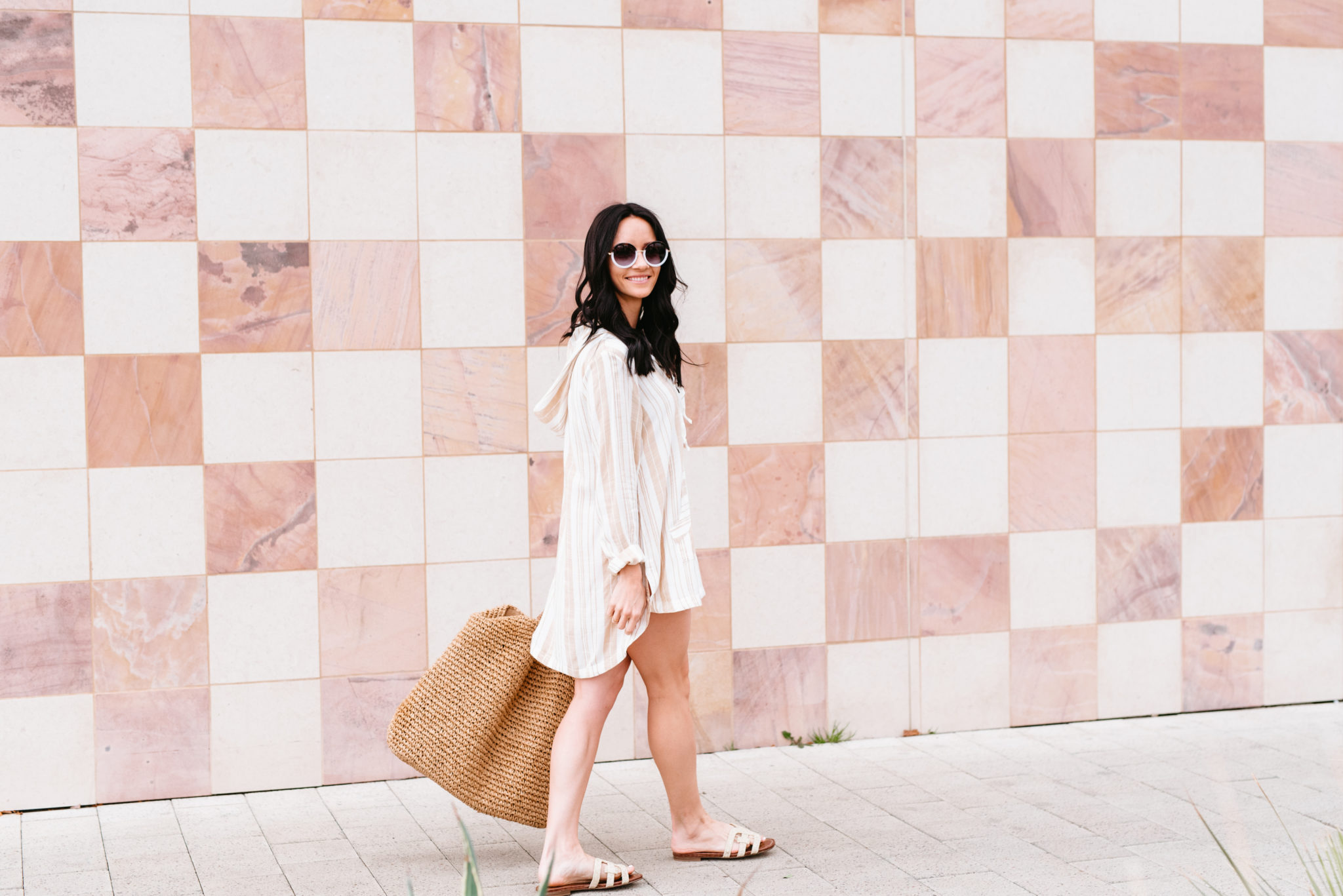 Top 15 Cute Swimsuit Coverups for Spring & Summer featured by top US fashion blog, Outfits & Outings: image of a woman wearing an L Space striped swimsuit coverup, mules, Nordstrom raffia tote and BP round sunglasses