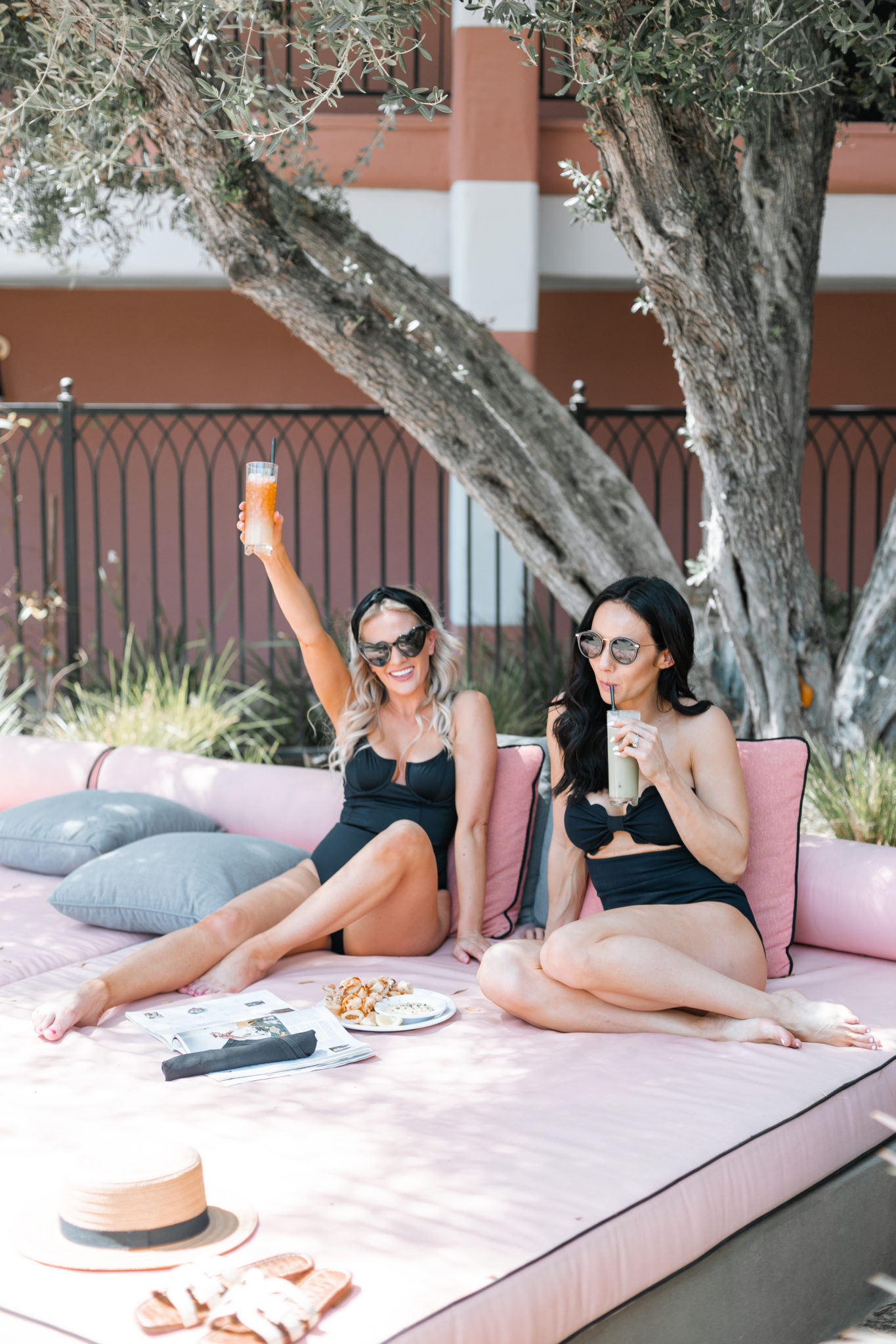 Shopbop Swimsuits roundup featured by top US fashion blog, Outfits and Outings: image of a woman wearing a black Marysia one piece swimsuit and Jimmy Choo aviator sunglasses