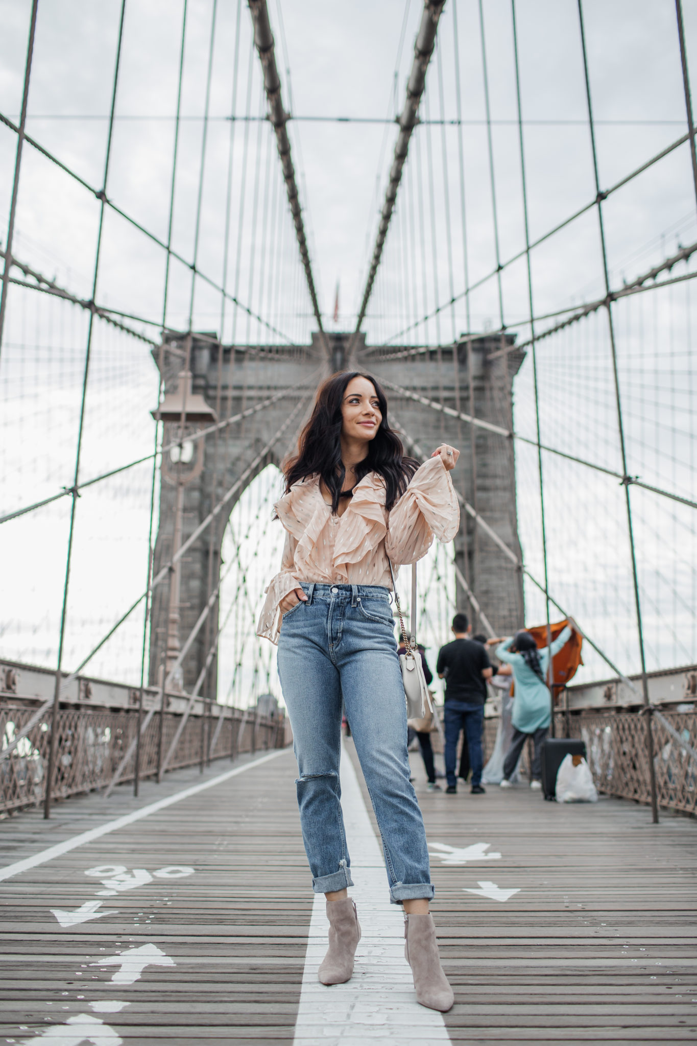 How to style a striped bodysuit for Fall, tips featured by top US fashion blog, Outfits & Outings: image of a woman wearing a REVOLVE striped bodysuit, SOCIALITE high waist slim jeans, and Vince Camuto suede booties.