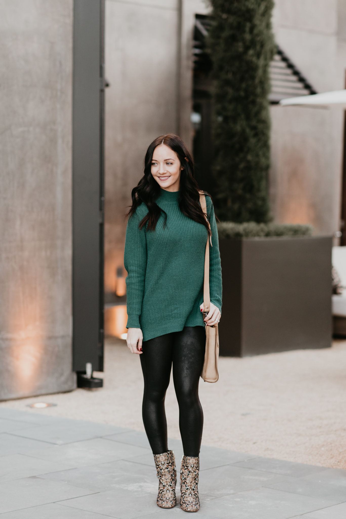 Festive Christmas Outfit Ideas featured by top US fashion blog, Outfits & Outings: image of a woman wearing a Caslon green sweater and Spanx Faux Leather leggings