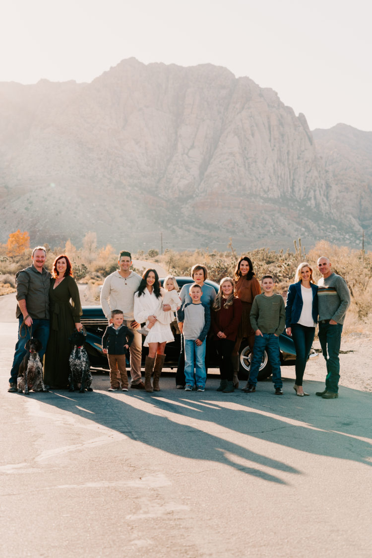 Family Picture Ideas by popular Las Vegas fashion blog, Outfits and Outings: image of a family standing together in the desert in front of a black vintage car. 