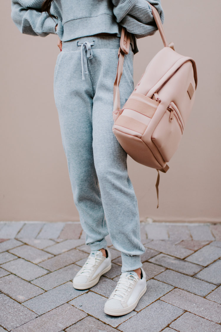 Matching Lounge Sets by popular Las Vegas fashion blog, Outfits and Outings: image of a woman holding a pink backpack and wearing a grey matching lounge set. 