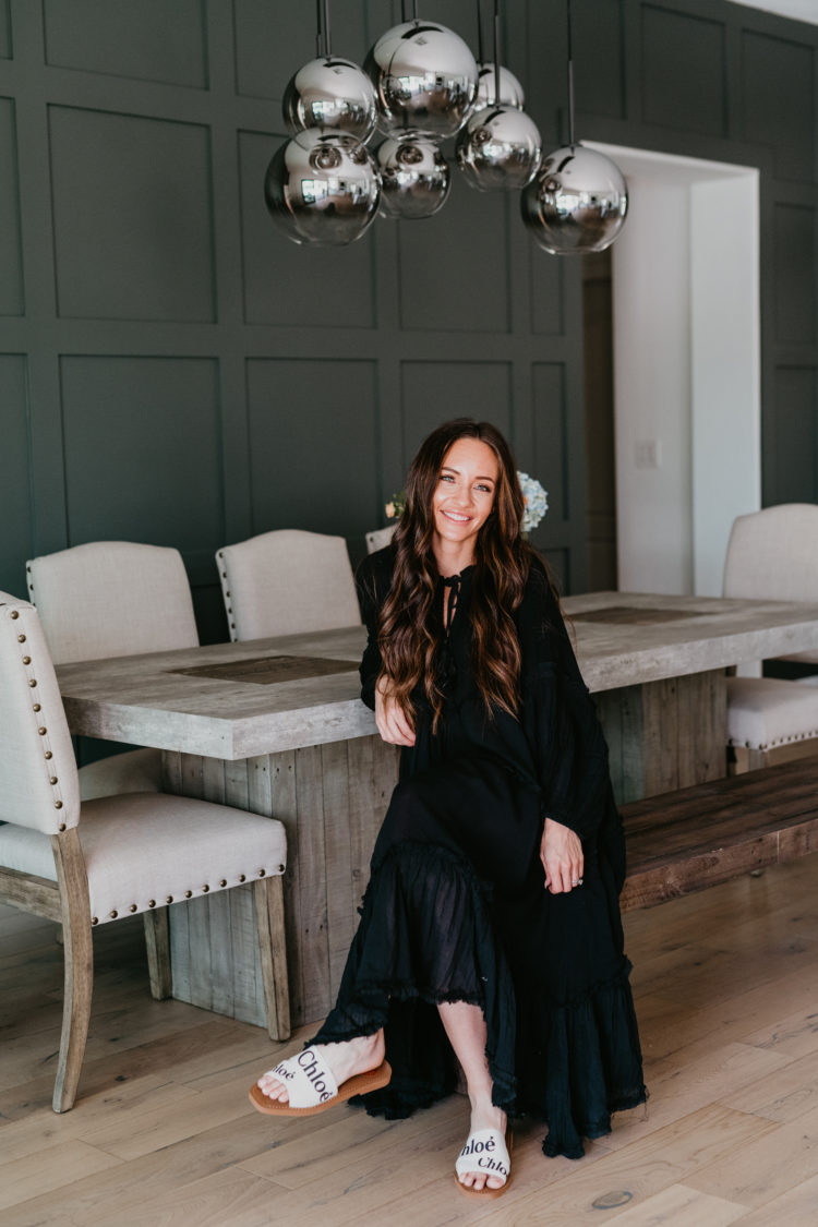 Copper and Tweed by popular Las Vegas life and style blog, Outfits and Outings: image of a woman wearing a black maxi dress and sitting at a Copper and Tweed dining table. 