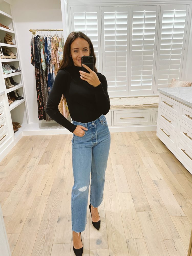 Nordstrom Anniversary Sale 2021 by popular Las Vegas fashion blog, Outfits and Outings: image of a woman wearing a black long sleeve shirt, light wash distressed jeans, and black heels. 
