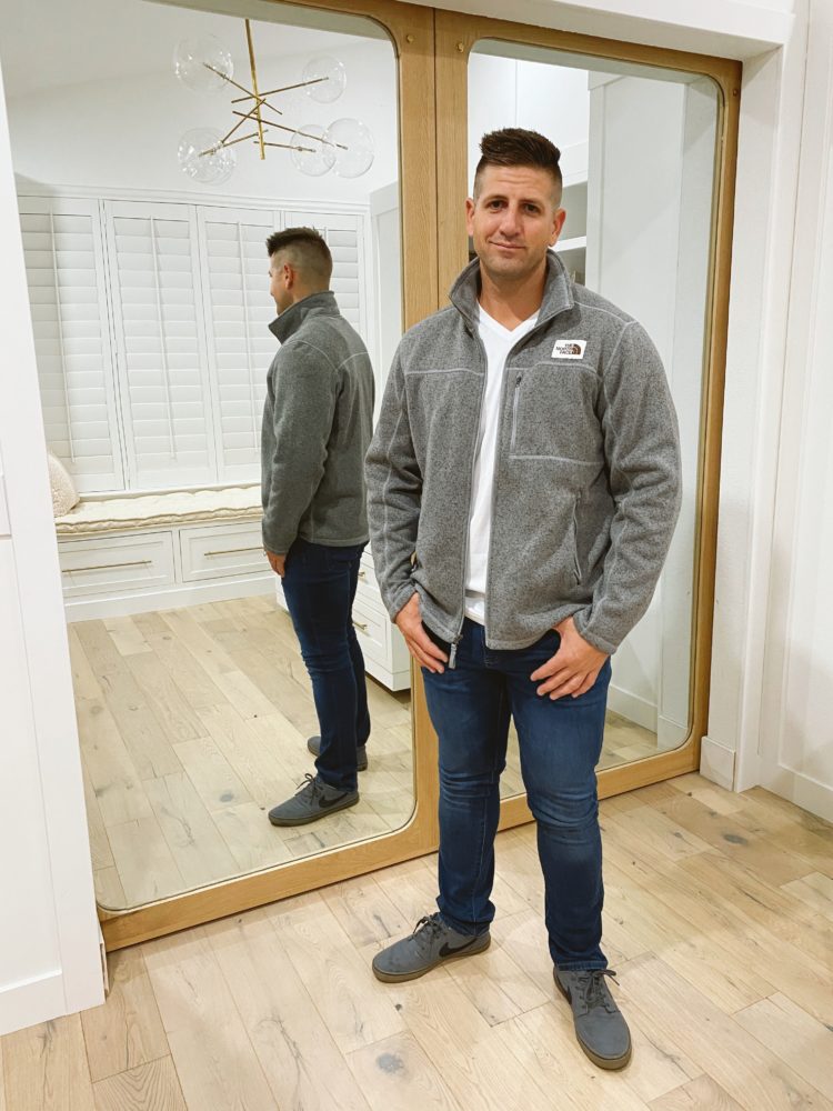 Nordstrom Anniversary Sale 2021 by popular Las Vegas fashion blog, Outfits and Outings: image of a man wearing a grey fleece North Face jacket, white t-shirt, jeans, and grey Nike sneakers. 