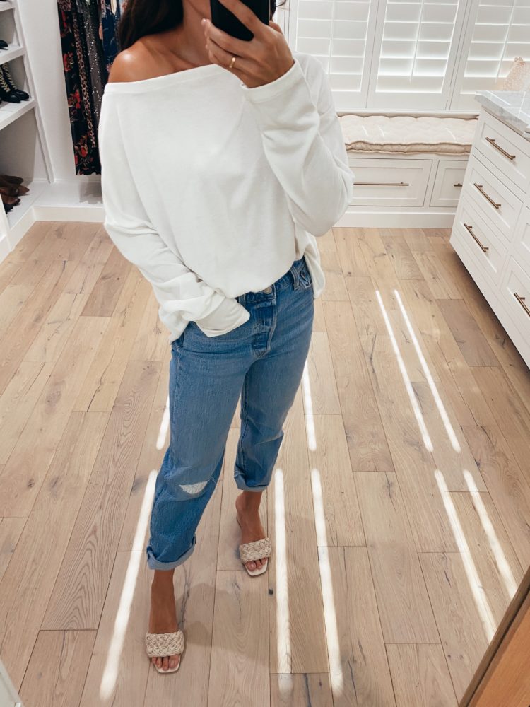 Nordstrom Anniversary Sale 2021 by popular Las Vegas fashion blog, Outfits and Outings: image of a woman wearing a white off the shoulder shirt, white light wash jeans, and tan braided strap heel sandals.