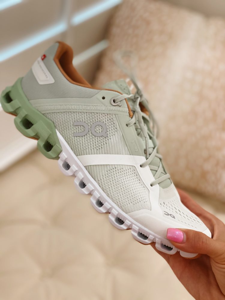 Nordstrom Anniversary Sale 2021 by popular Las Vegas fashion blog, Outfits and Outings: image of a woman holding a pair of white, grey, and green athletic sneakers. 