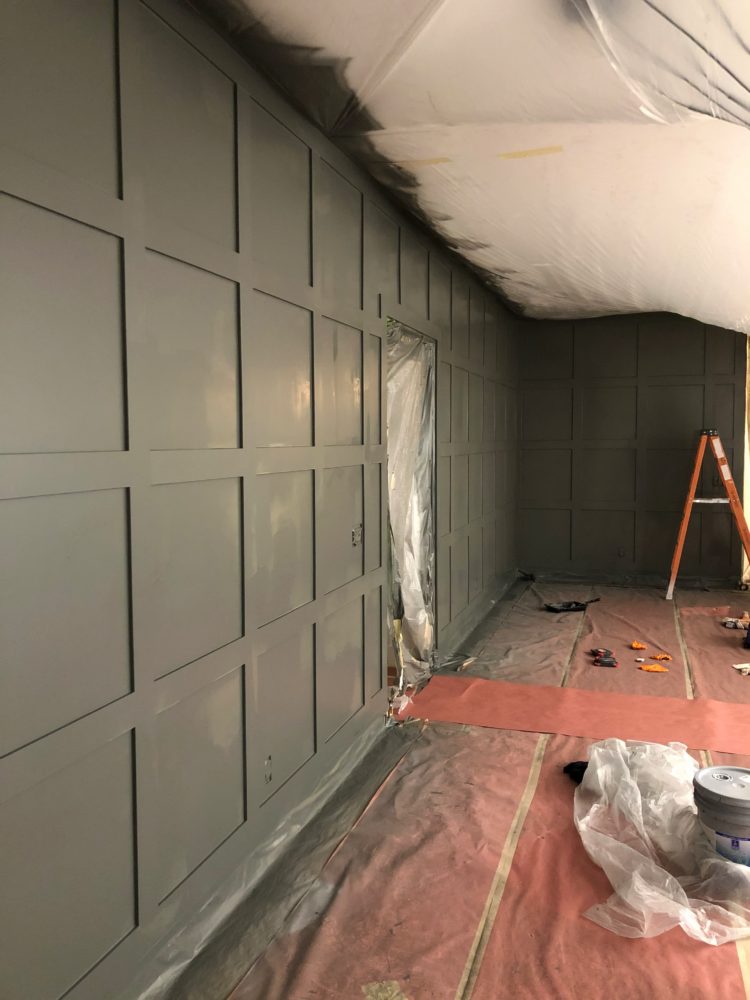 DIY Accent Wall by popular Las Vegas life and style blog, Outfits and Outings: image of a board and batten accent wall being painted grey.  